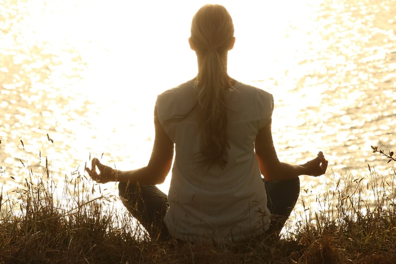 Yoga man meditating at sunset